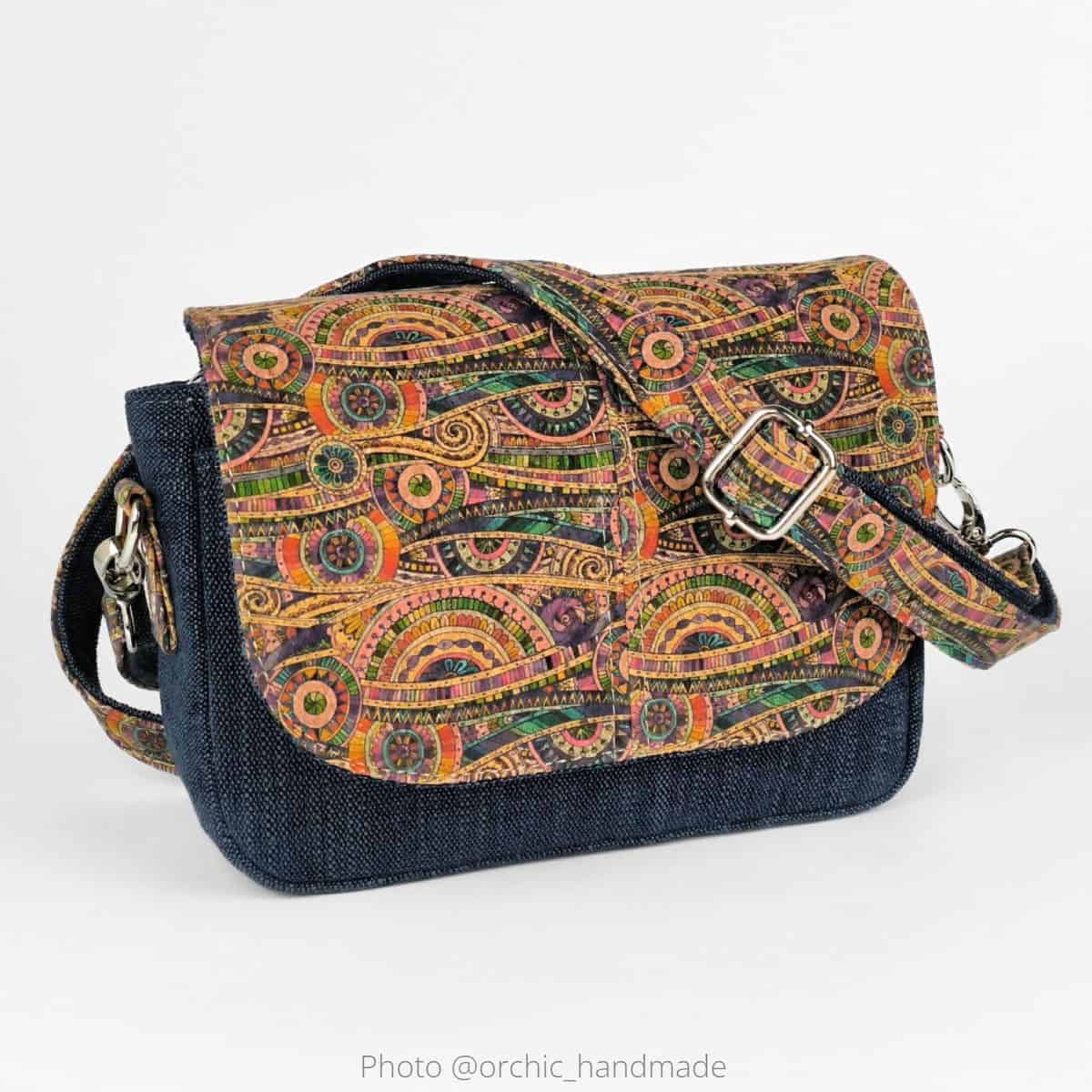 A finished handmade flap bag sewn with heavy denim and printed cork.