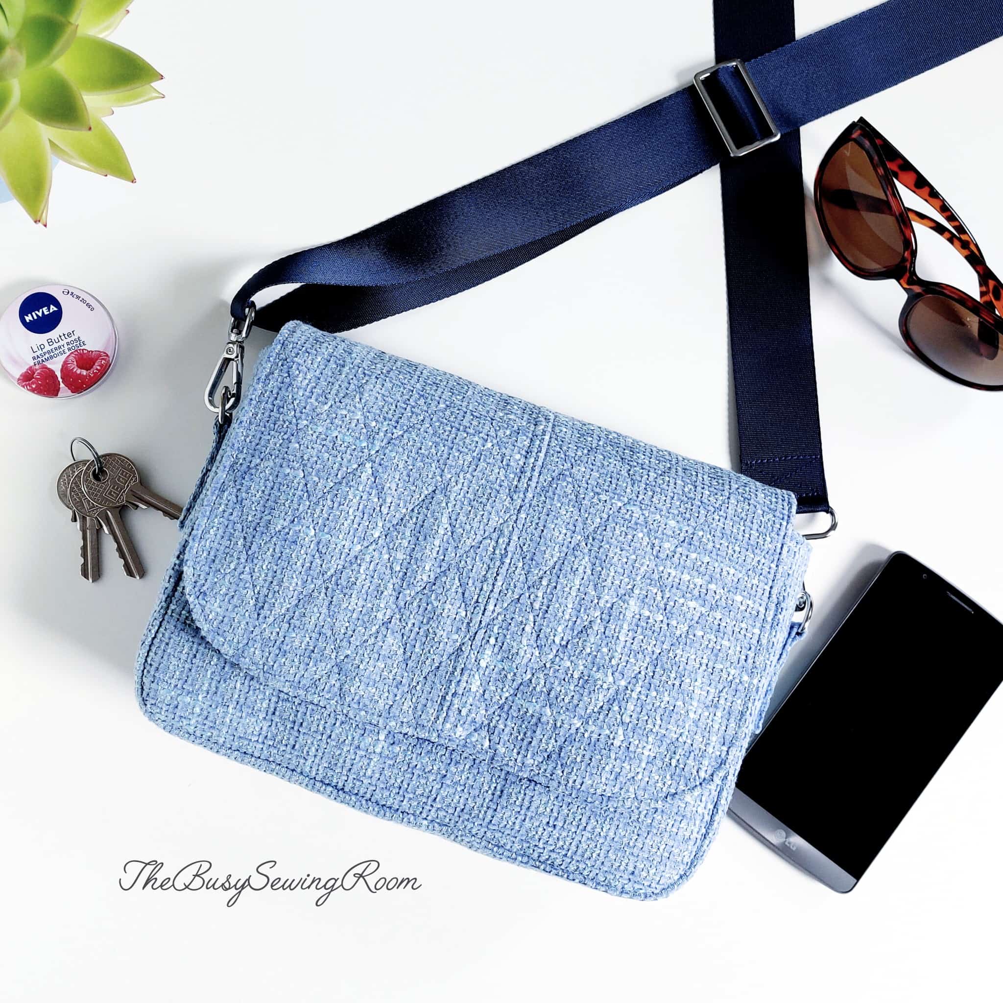 A finished handmade purse with a flap, sewn with sky-blue decor-weight fabric.