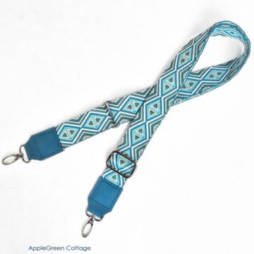 Adjustable bag strap with blue leather strap connectors and webbing strap.