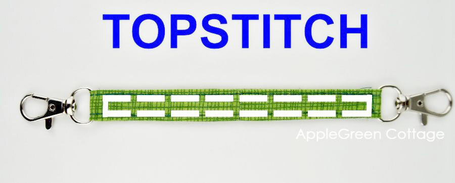 A fabric strap with two swivel hooks for a bag, ready to be topstitched.