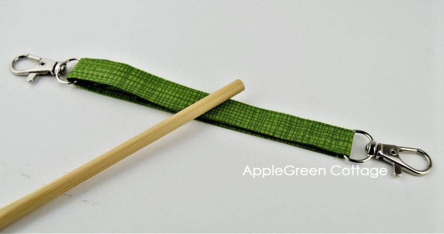 A fabric strap with two swivel hooks for a bag.