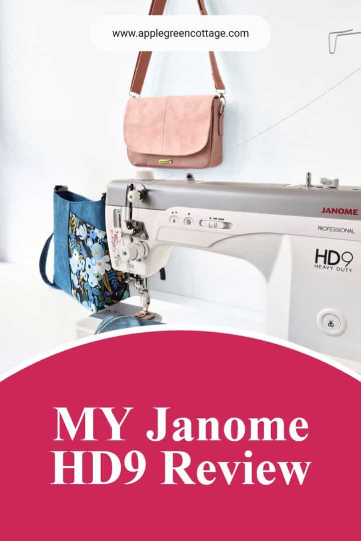 A finished handmade purse with a flap in light blue faux leather placed on a janome hd9 sewing machine