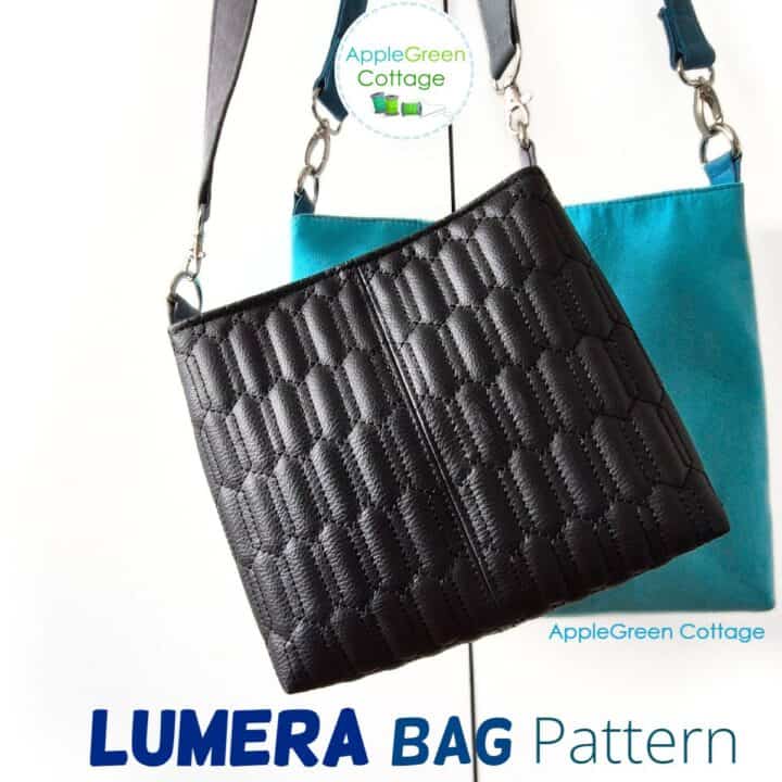 A beautiful handmade black faux leather bag hanging on a sleek faux leather shoulder strap.