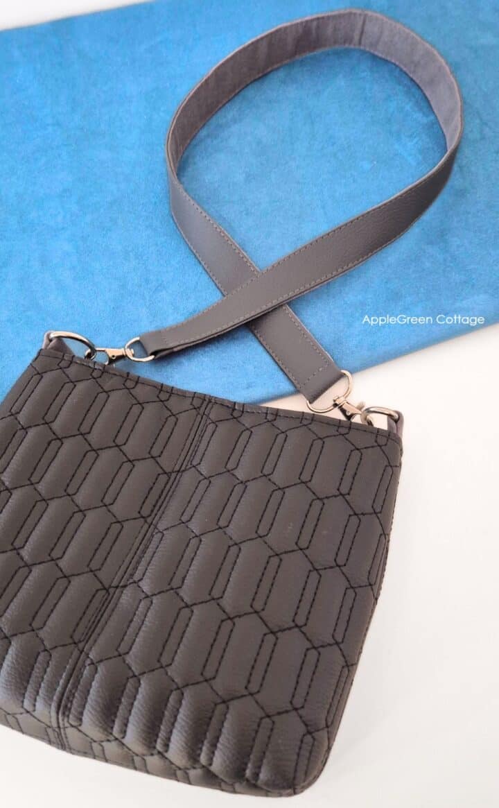 Finished faux leather shoulder strap attached to a faux leather bag.