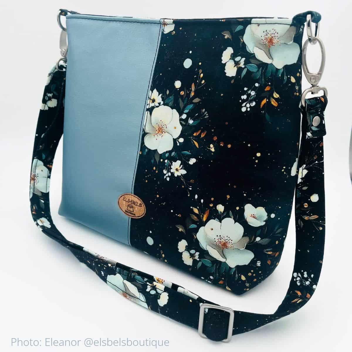 Floral and faux leather Lumera bag with half-and-half panel and adjustable strap.