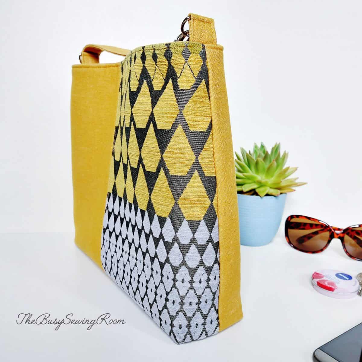 Mustard and geometric print Lumera bag with boxed corners and structured sides.