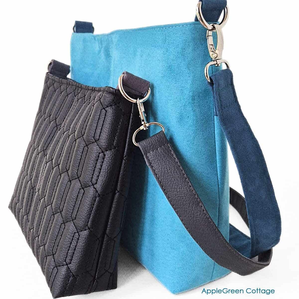 Two beautiful handmade bags on a white table, one is black faux leather bag and the other is a regular size teal faux suede bag with a shoulder strap.