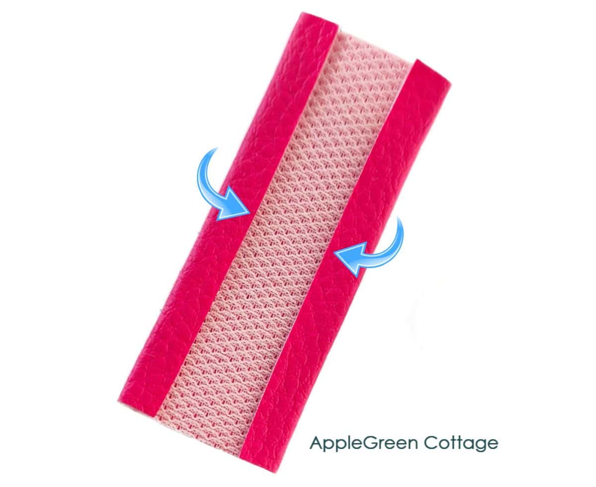 Faux leather strap connector showing long edges folded inward to reduce bulk.