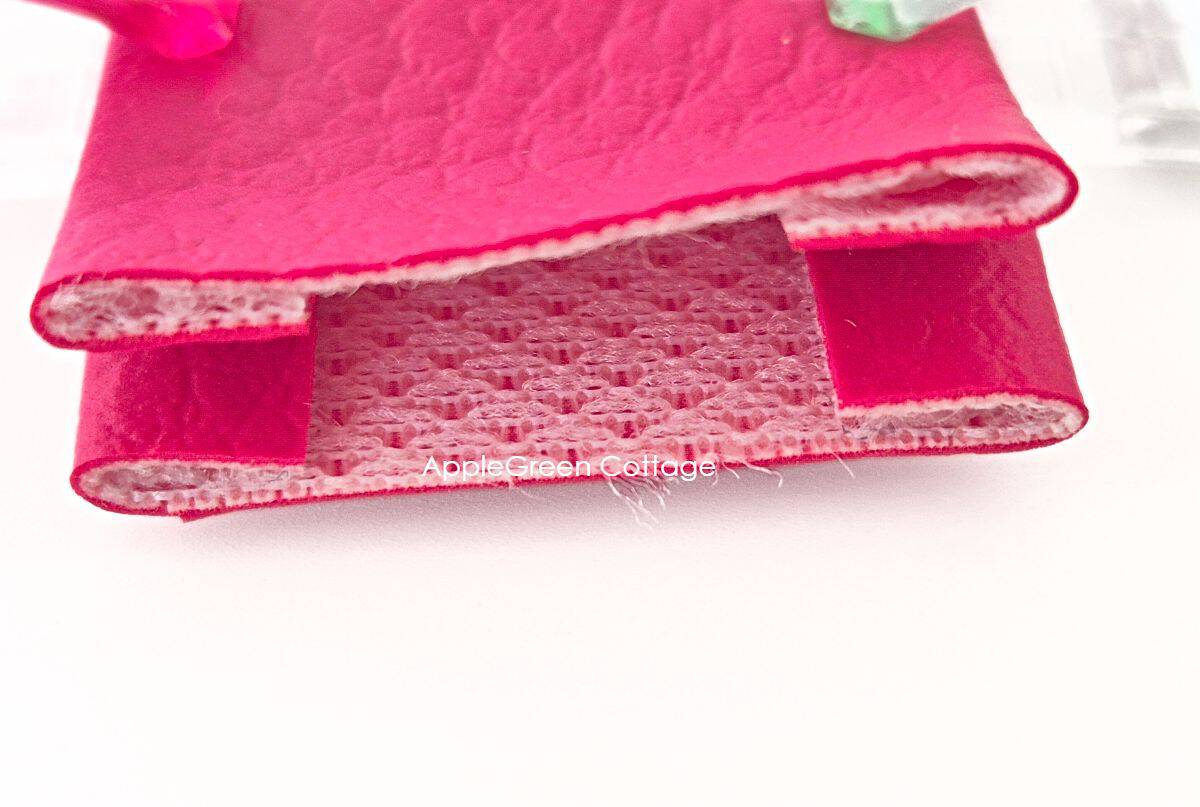 Faux leather strap connector folded with trimmed inner layers to reduce bulk before topstitching.