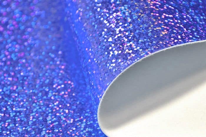 Glitter vinyl sheet with smooth fabric backing for bagmaking.