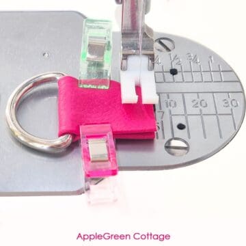 Sewing faux leather strap connector with D-ring under the presser foot for a low-bulk bagmaking technique.