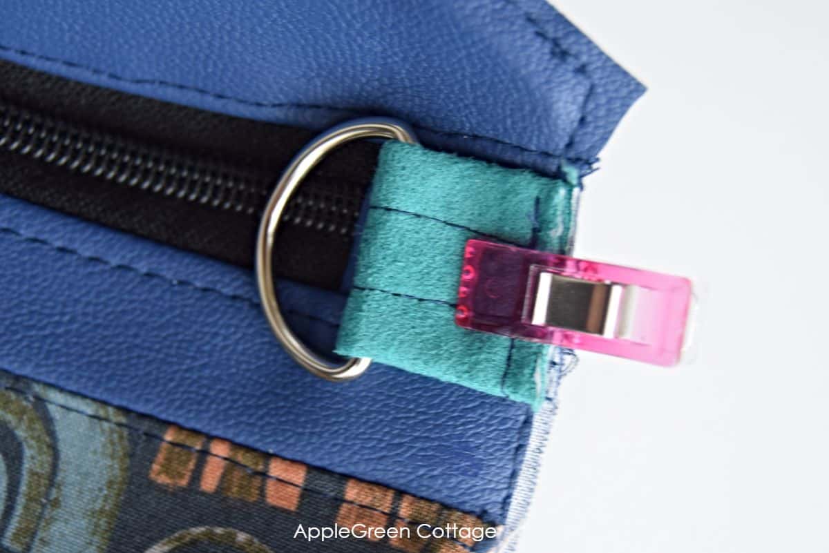 Low-bulk strap connector sewn into a zippered bag corner using faux leather and quilting cotton.