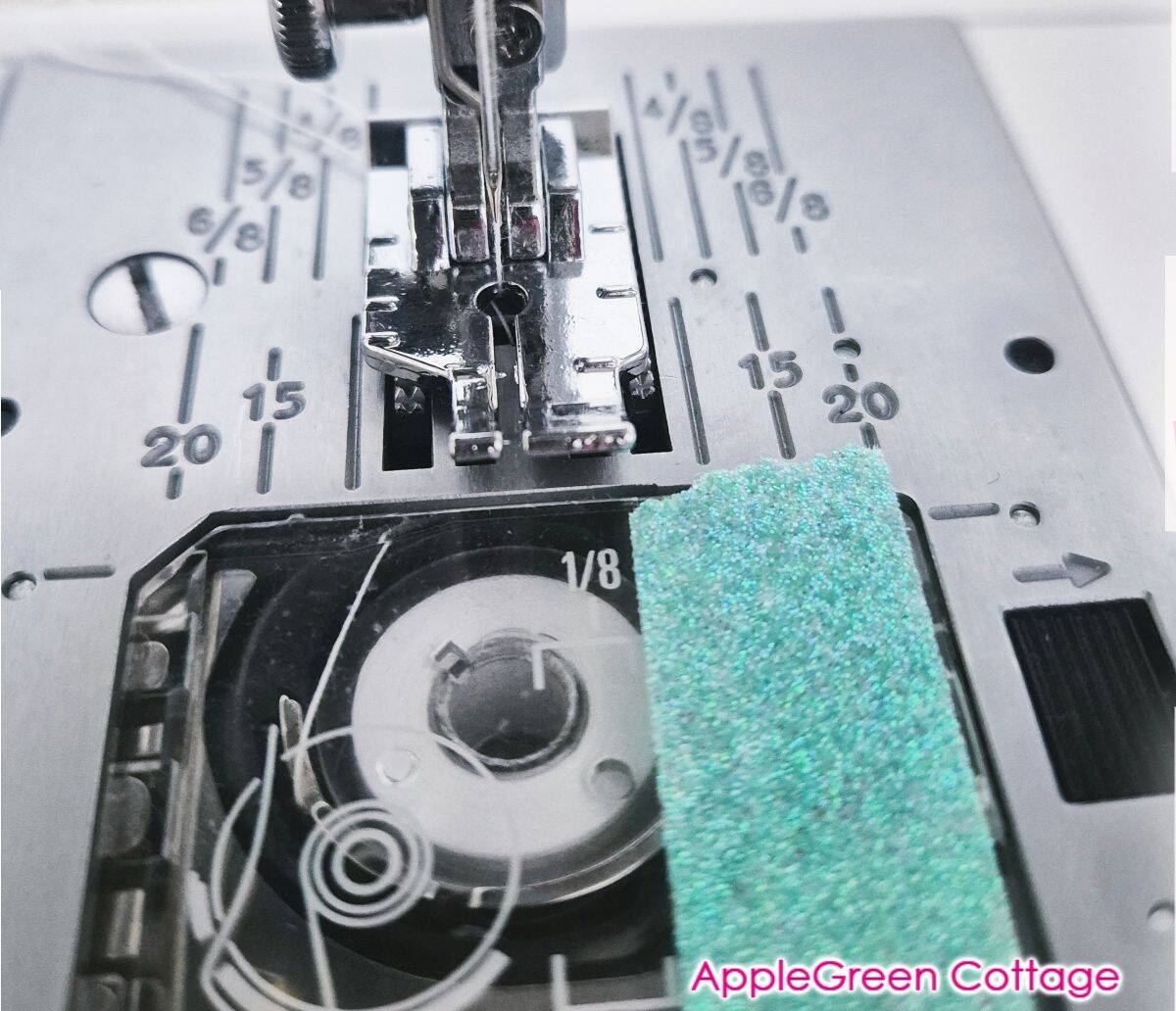 Tape guide placed on sewing machine bed to maintain a straight quarter inch quilting seam.