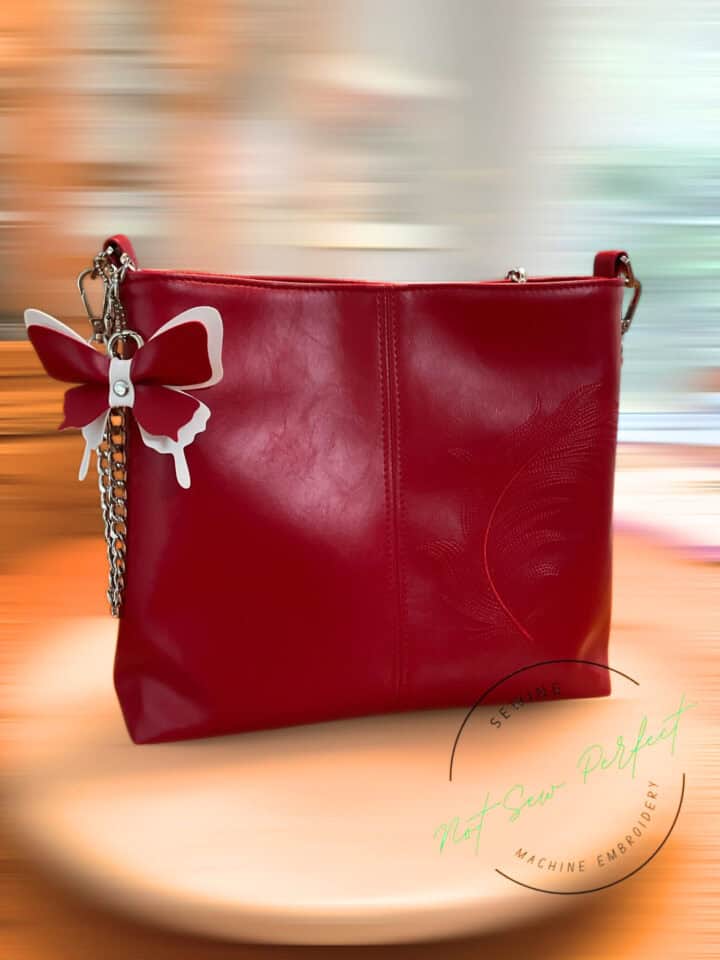 A beautiful handmade lumera shoulder bag sewn with classic red faux leather and with embroidered leaf shape.
