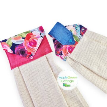 Two handmade hanging kitchen towels with floral fabric toppers and snap tabs.