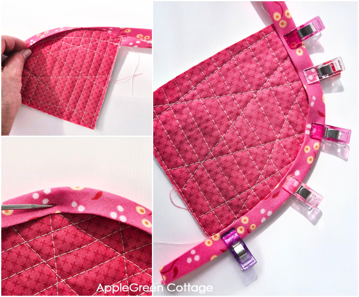 Bias tape pinned around curved quilt corner, ready for topstitching.