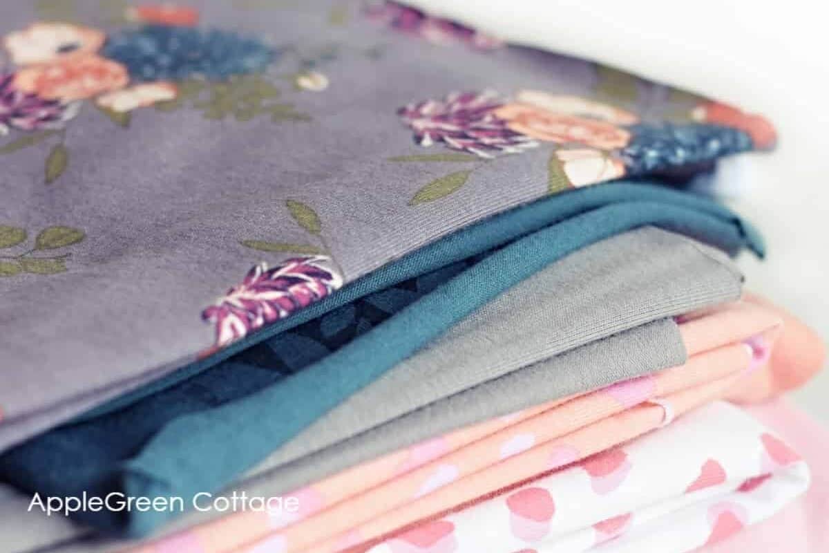 A pile of knit fabrics in different prints and colors.