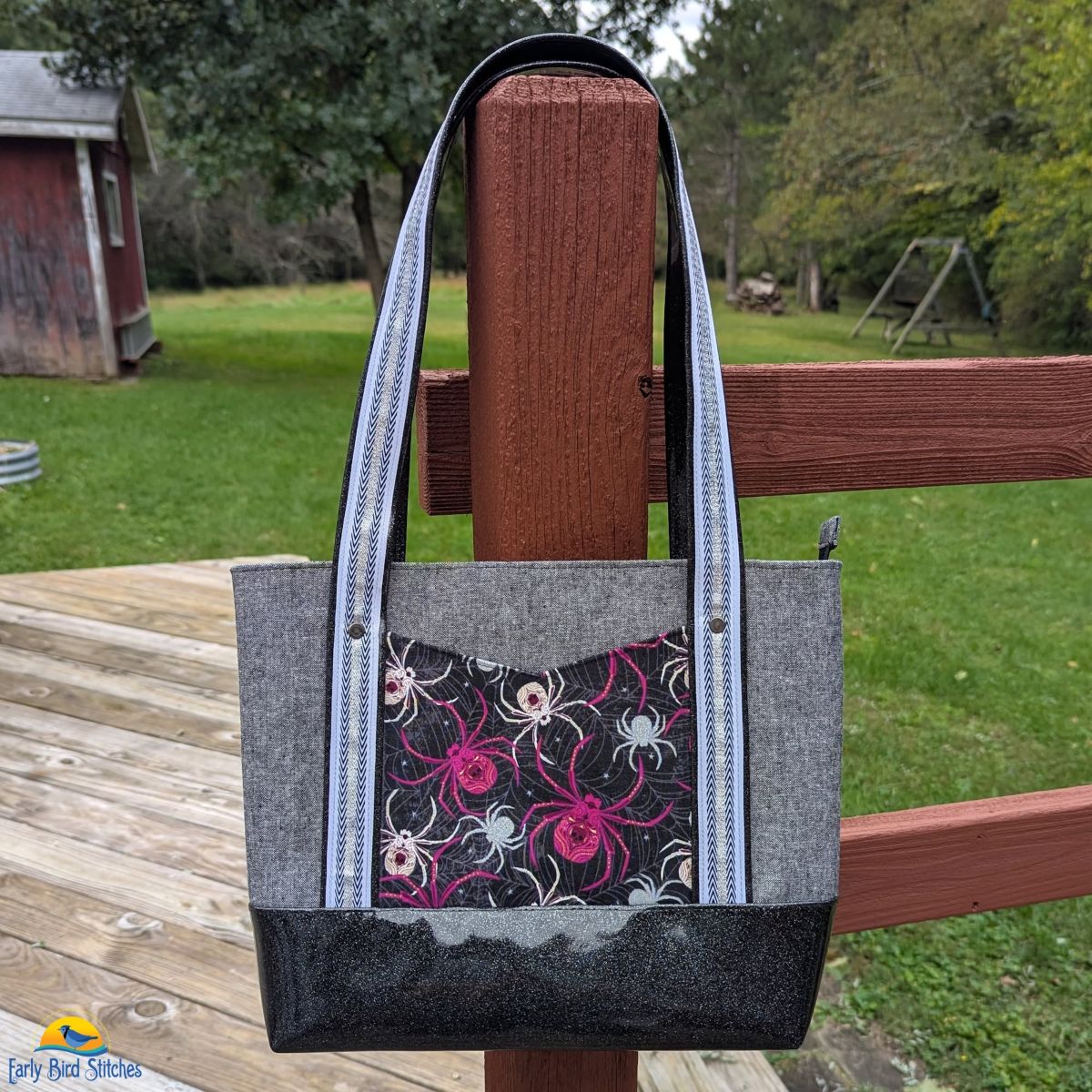 Gray Halloween tote bag with spider-print front pocket, black accents, and long handles.