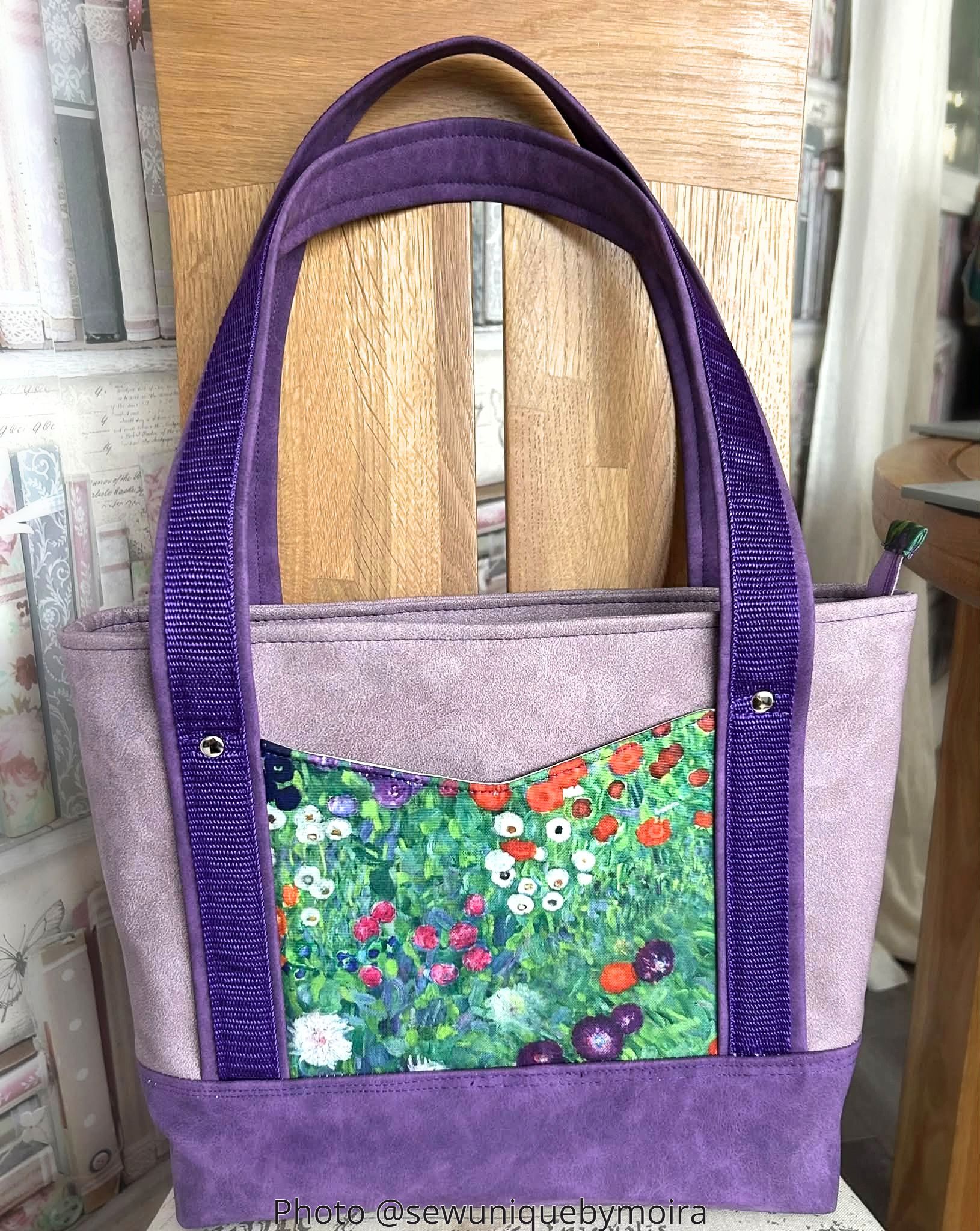 Purple AVELA tote with poppy-print front pocket, purple handles, and structured base.